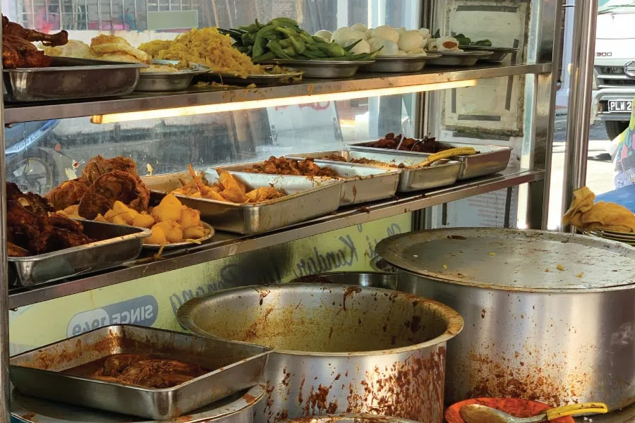 dishes and curries displayed on trays on racks