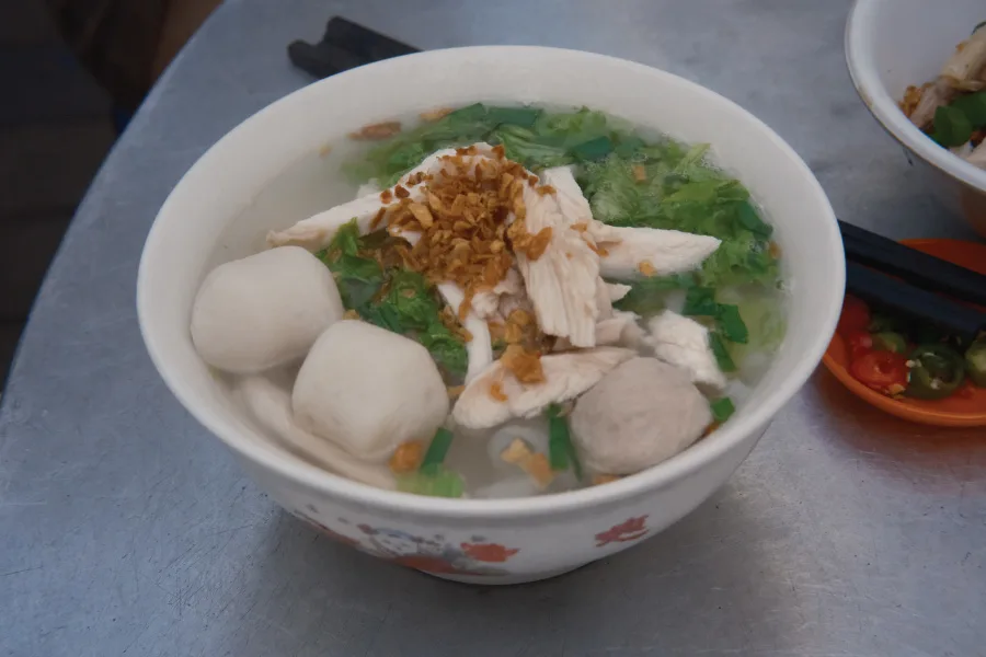 bowl of noodles with soup, meat, fishballs