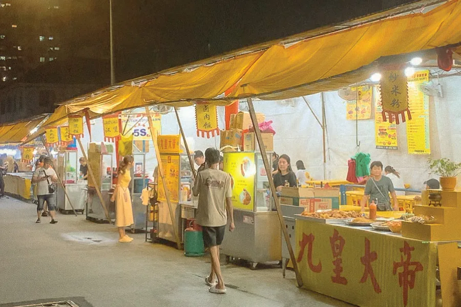 food stalls set up with yellow signage and canopy by the streets